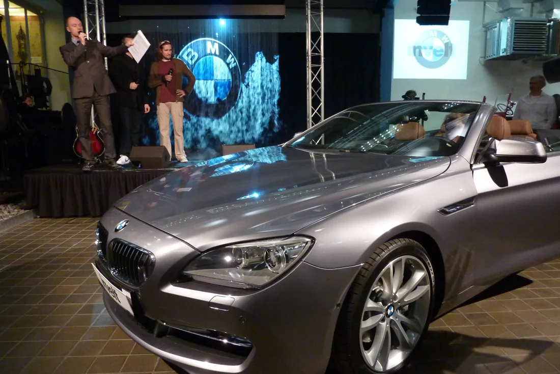 Prezentace kabrioletu BMW s mlžnou projekcí loga v pozadí.