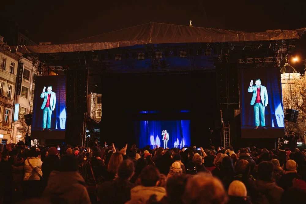 Wide view of the stage, side screens and audience